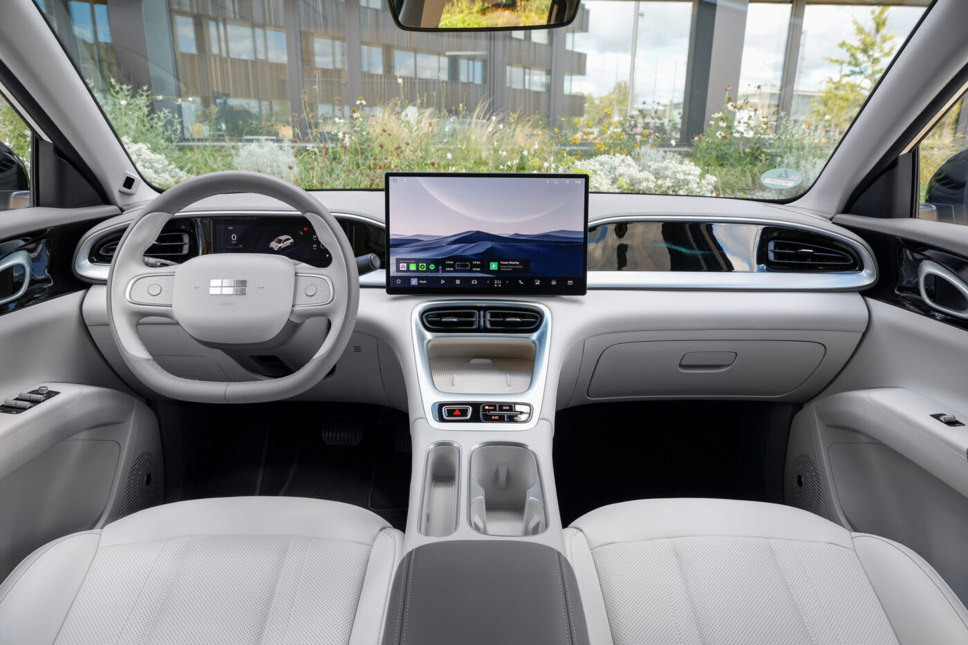 Geely E2 Cockpit mit großem Zentraldisplay, hellem Leder-Interieur und schlichtem Lenkrad