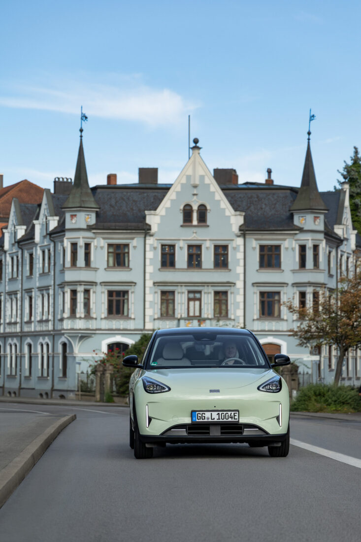 Geely E2 in Hellgrün, Frontansicht auf einer deutschen Stadtstraße vor Gründerzeitgebäude