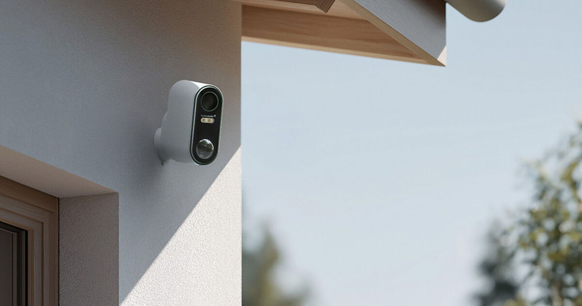 Homematic IP Akku-Außenkamera HmIP-COR an weißer Hausfassade unter Dachvorsprung montiert