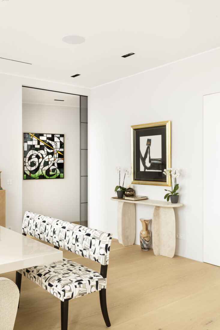 Helles Berliner Penthouse-Wohnzimmer mit gemusterter Bank, Naturstein-Konsole und abstrakter Kunst