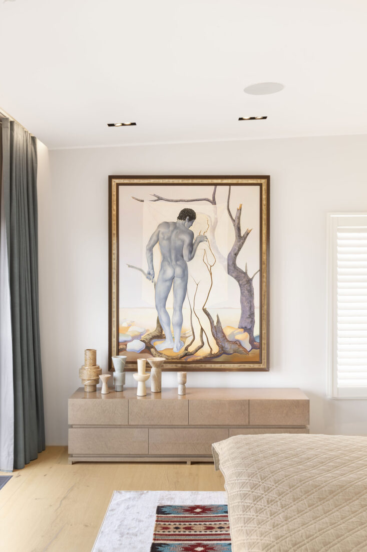 Schlafzimmer im Berliner Penthouse mit großformatigem Gemälde über Sideboard und dezenter Einbautechnik