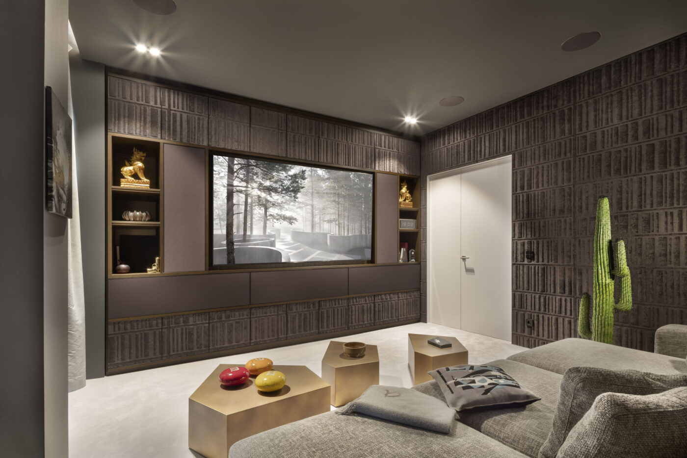 Heimkino-Raum im Berliner Penthouse mit großem Bildschirm, KNX-gesteuerter Beschallungsanlage und goldfarbenem Couchtisch