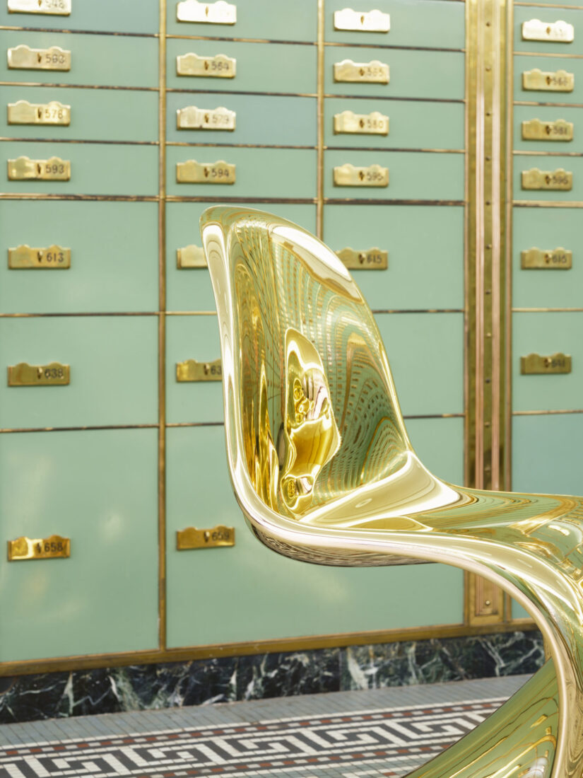 Goldener Panton Chair vor mintgrünen Schließfächern mit Messingbeschlägen