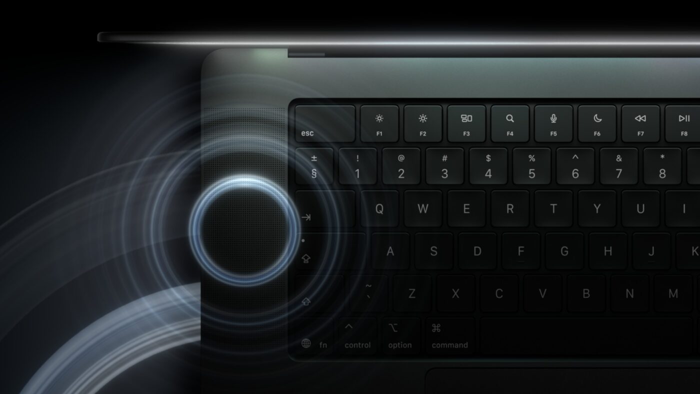 MacBook Pro Tastatur-Nahaufnahme mit beleuchtetem Lautsprechergitter und blauem Leuchteffekt