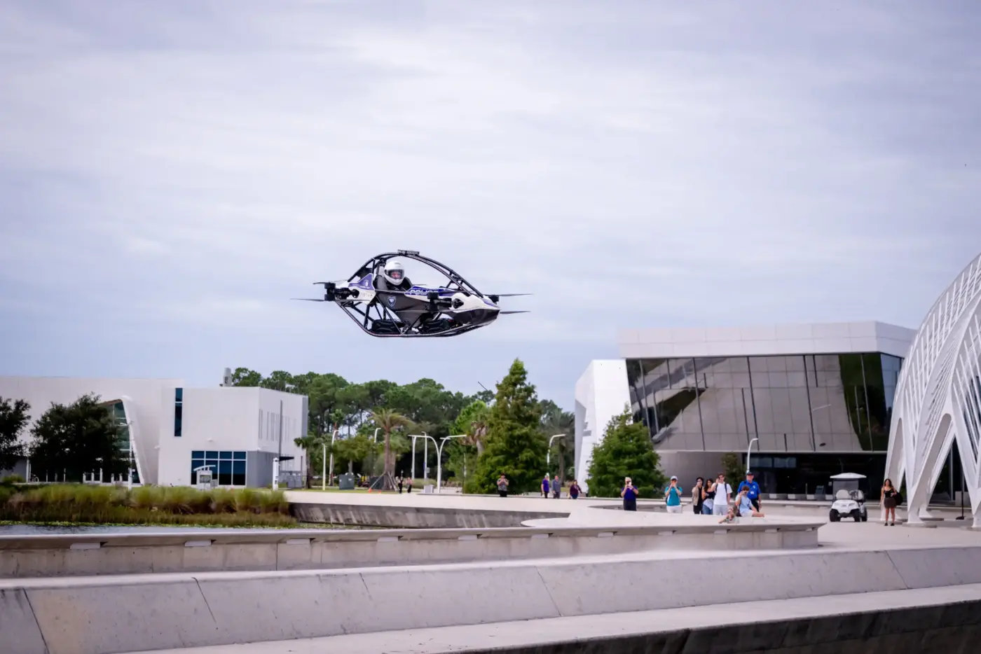 Jetson ONE „Astro" im Flug über dem Campus der Florida Polytechnic University mit helmtragem Piloten