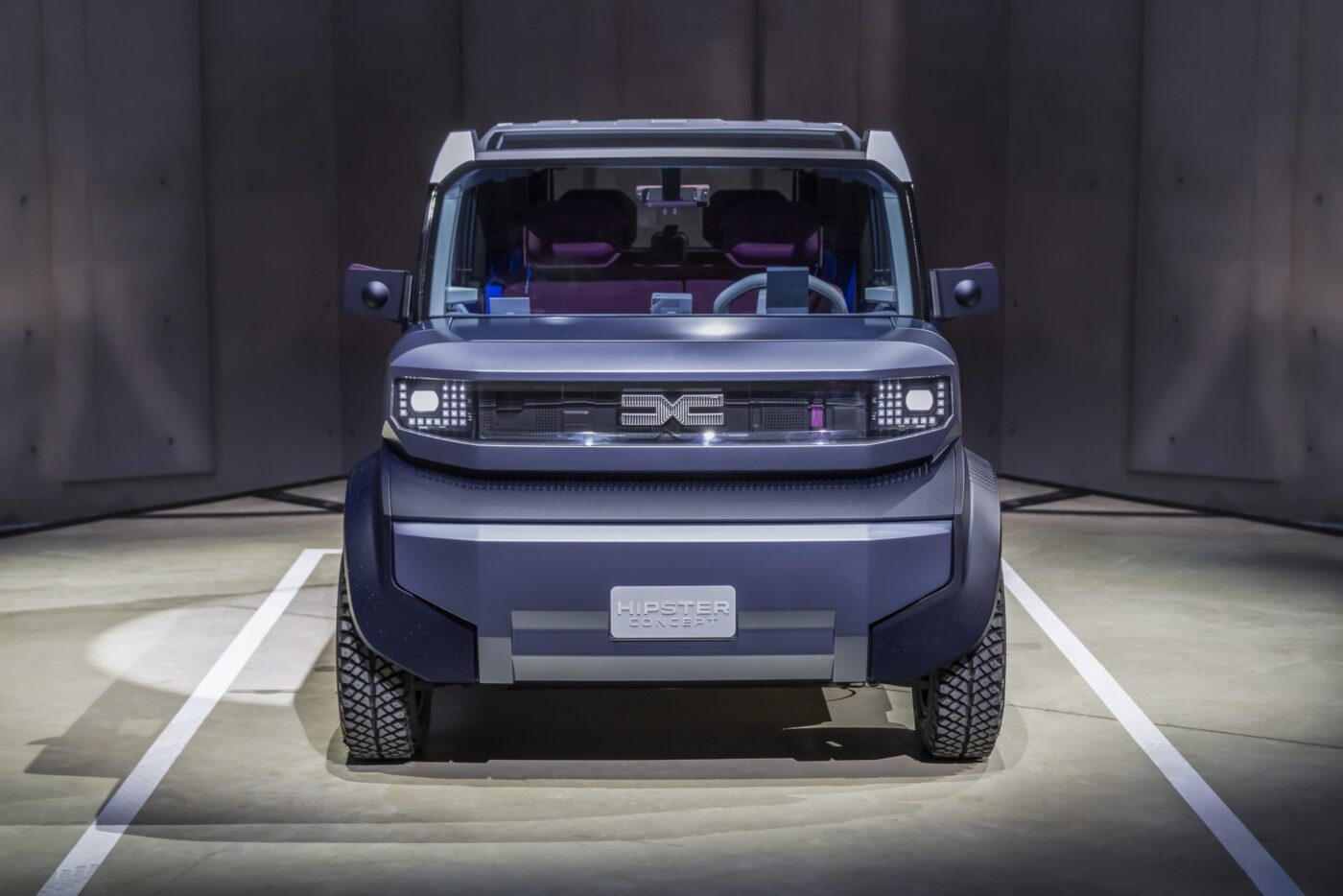 Dacia Hipster Concept in Frontansicht: blauer L7e-Elektrowürfel mit lila Innenraum und LED-Scheinwerfern