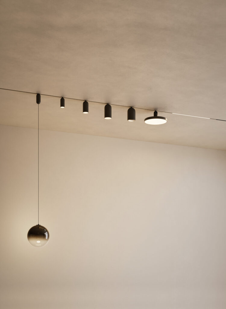 Lodes DoubleZero7 Schienensystem mit schwarzen Zylinderspot, flacher Deckenleuchte und Kugelpendelleuchte