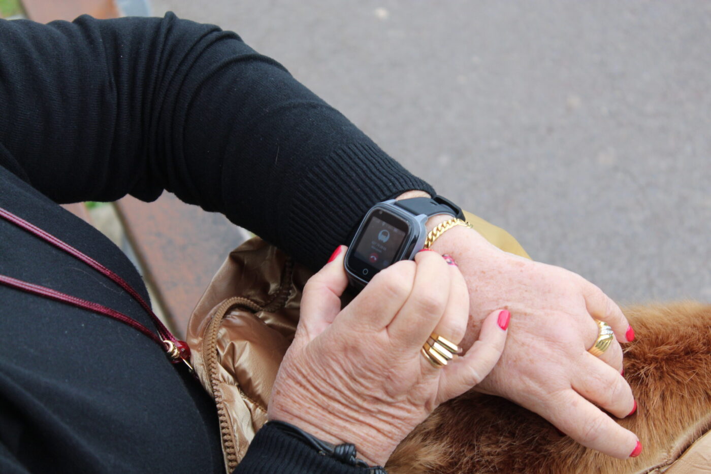 Ältere Frau bedient SaveFamily Senior Smartwatch am Handgelenk, Display zeigt eingehenden Anruf