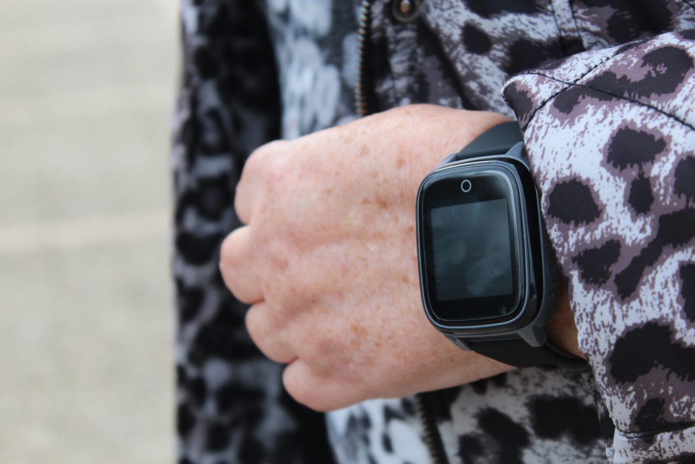 SaveFamily Senior Smartwatch mit schwarzem Gehäuse und Frontkamera am Handgelenk einer älteren Person