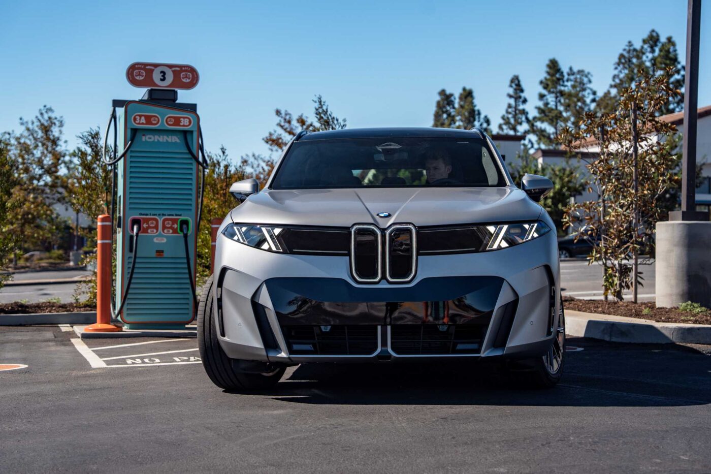 BMW iX5 60 xDrive frontal an einer IONNA-Schnellladesäule in Kalifornien