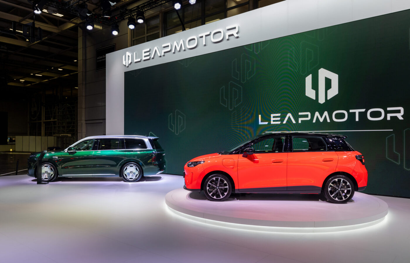 Leapmotor B03 in Orange-Rot auf dem Pariser Autosalon, daneben ein grüner Leapmotor-SUV