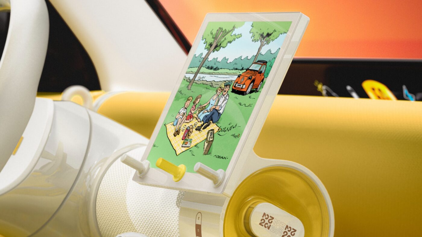 Citroën 2CV Interieur mit Tablet-Halter, auf dem eine Comic-Szene mit Picknick und orangem 2CV abgebildet ist