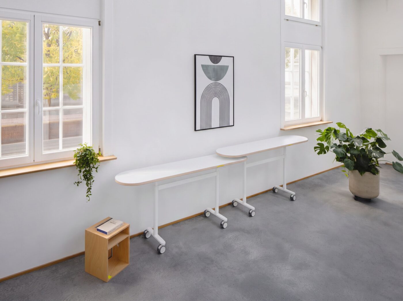 Zwei Personen arbeiten an verbundenen Studiotools HighLow Tables in einem Projektraum